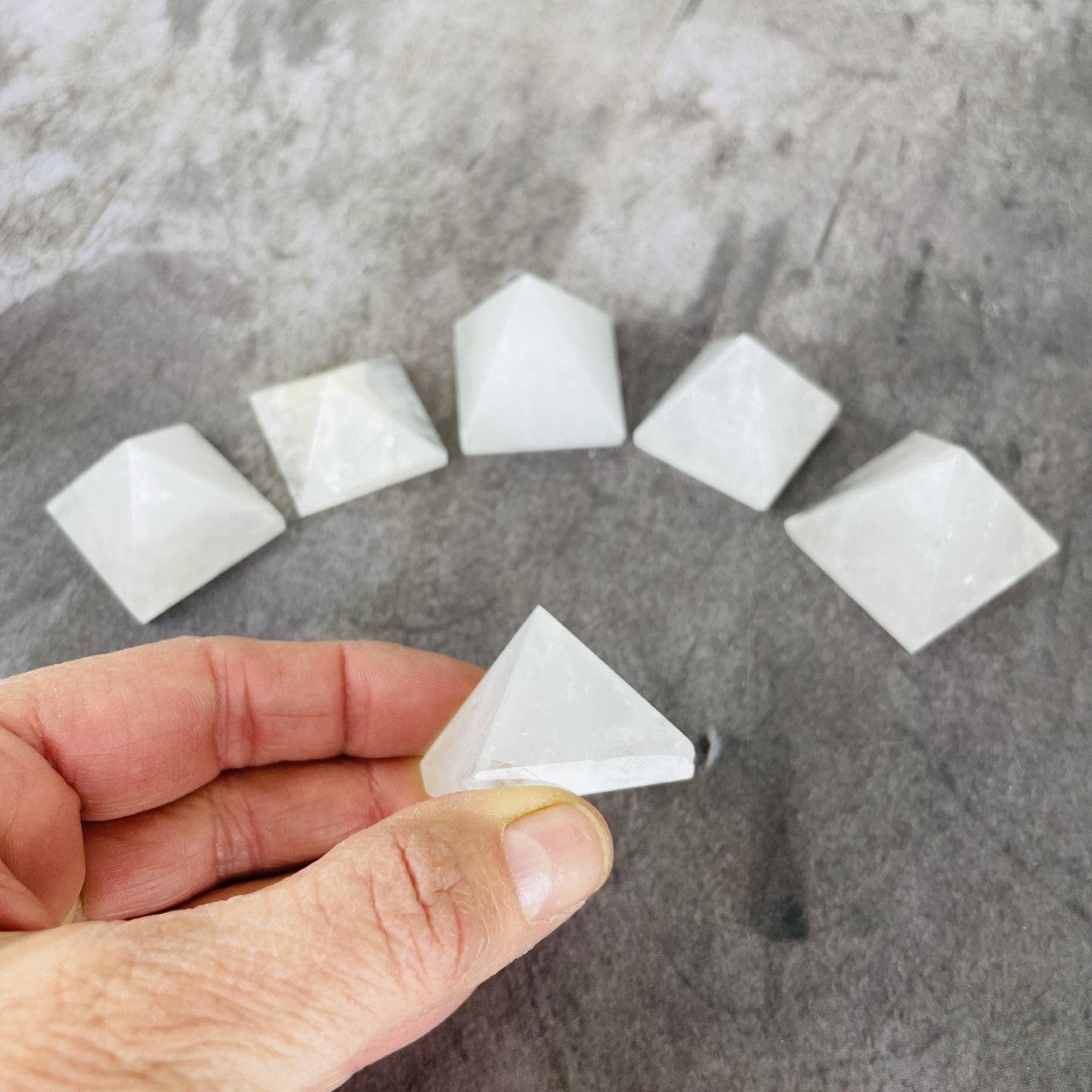 Crystal Quartz Pyramid 1.25" size, one in a hand for size reference
