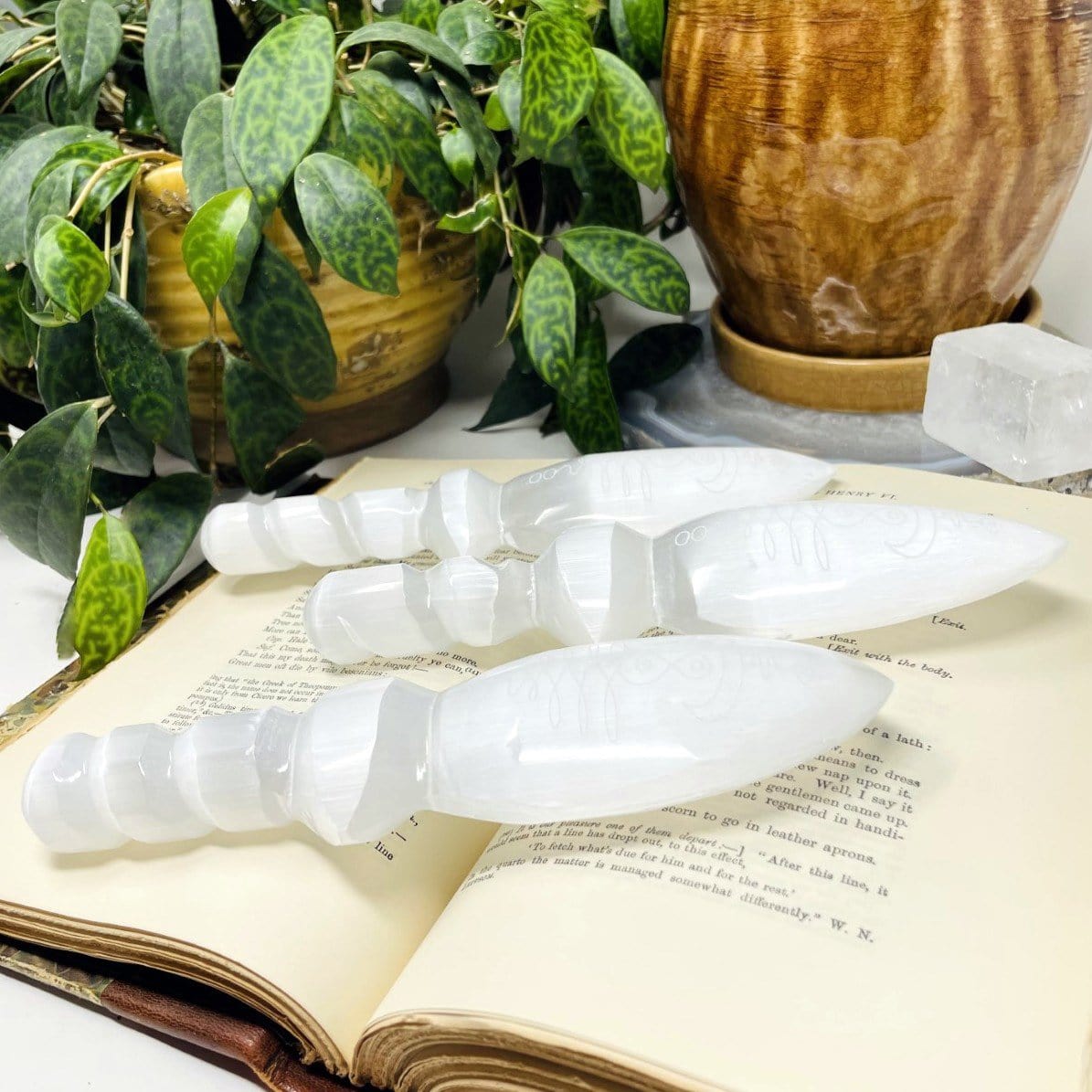 angled view of selenite twisted handle knives with unalome engraving 
