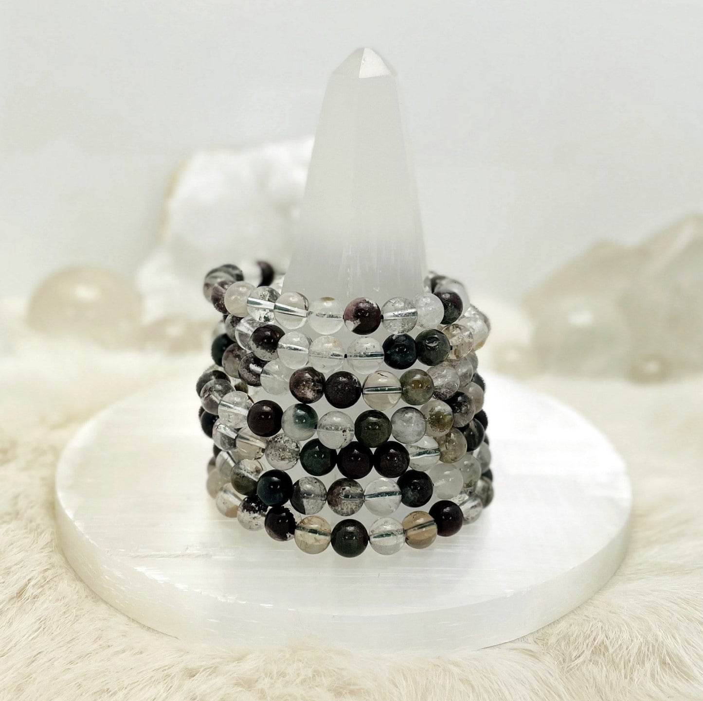 Lodolite bracelets stacked on a stand.