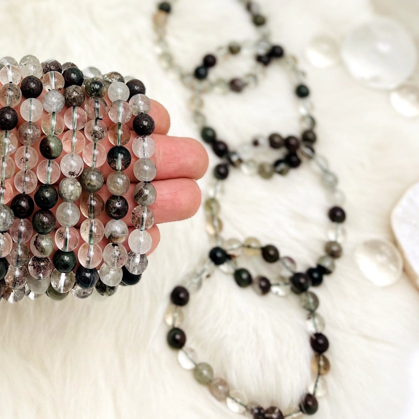 Multiple Lodolite bracelets displayed on fingers.