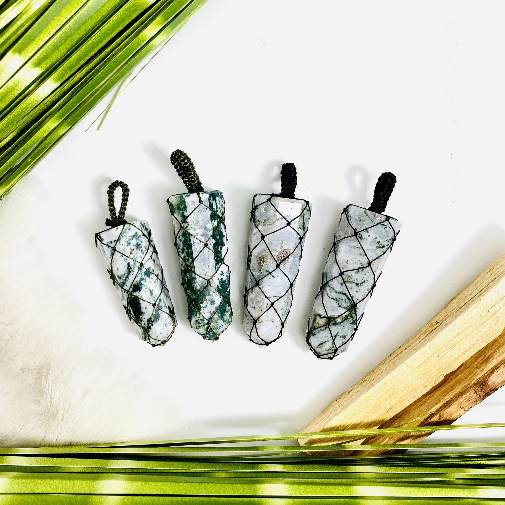 4 moss agate netted points with decorations in the background
