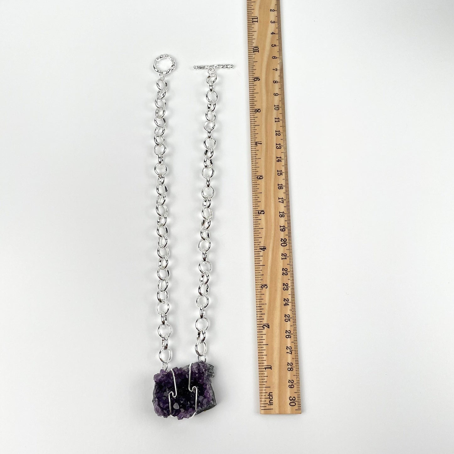 necklace next to a ruler for size reference 