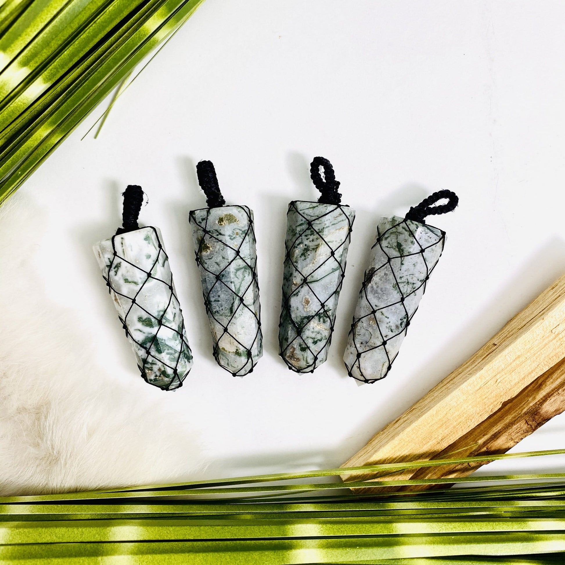4 moss agate netted pendants with decorations in the background