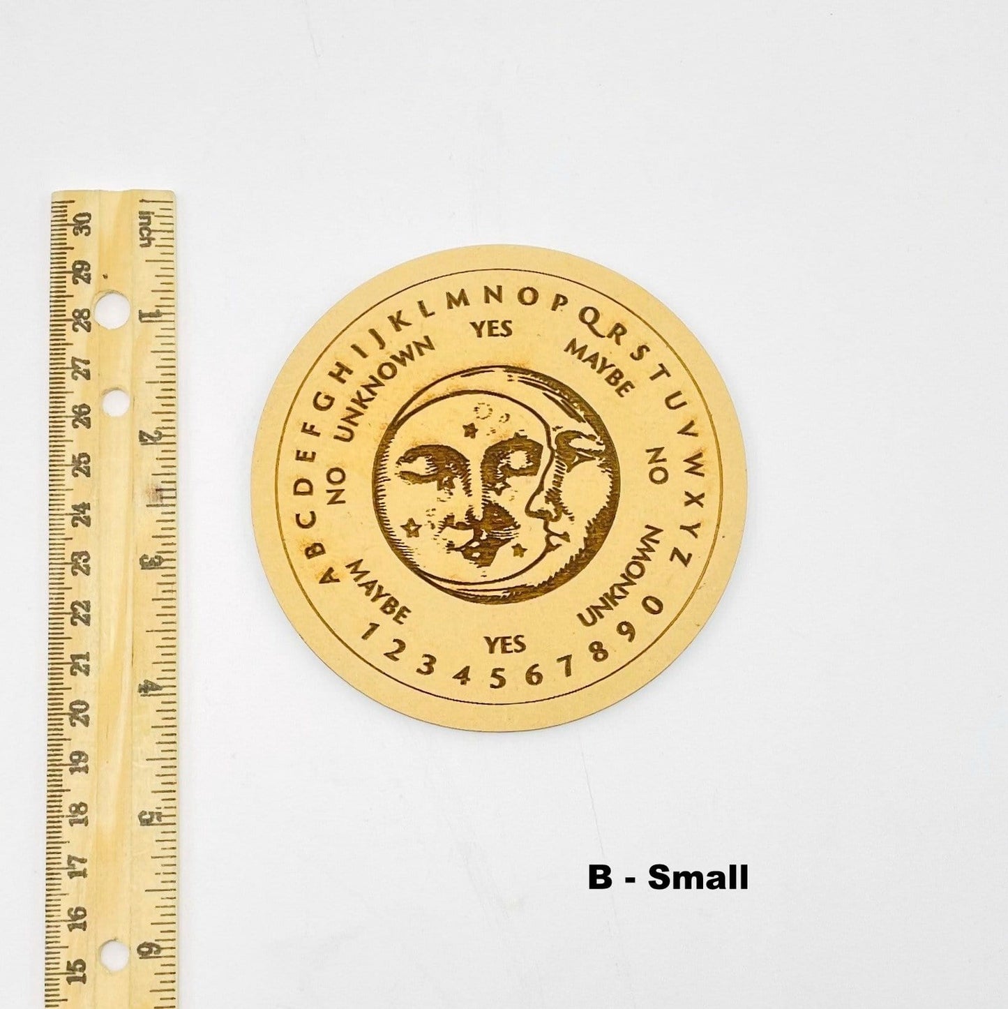 small board next to a ruler for size reference 