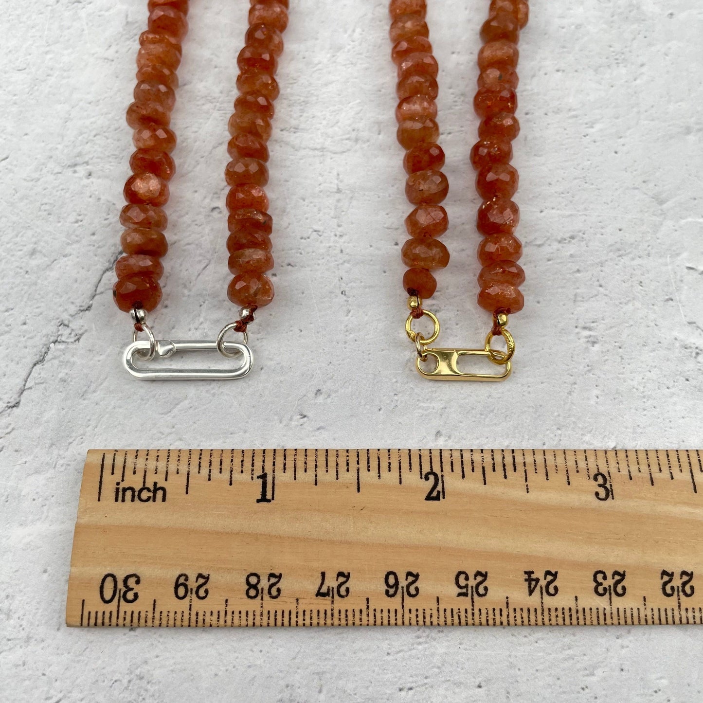 clasps next to a ruler for size reference 