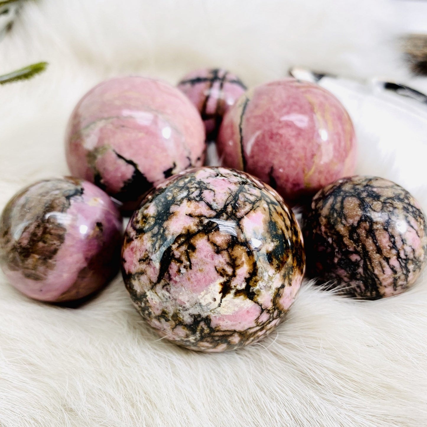 Up close shot of 6 Rhodonite Polished Spheres on fur background