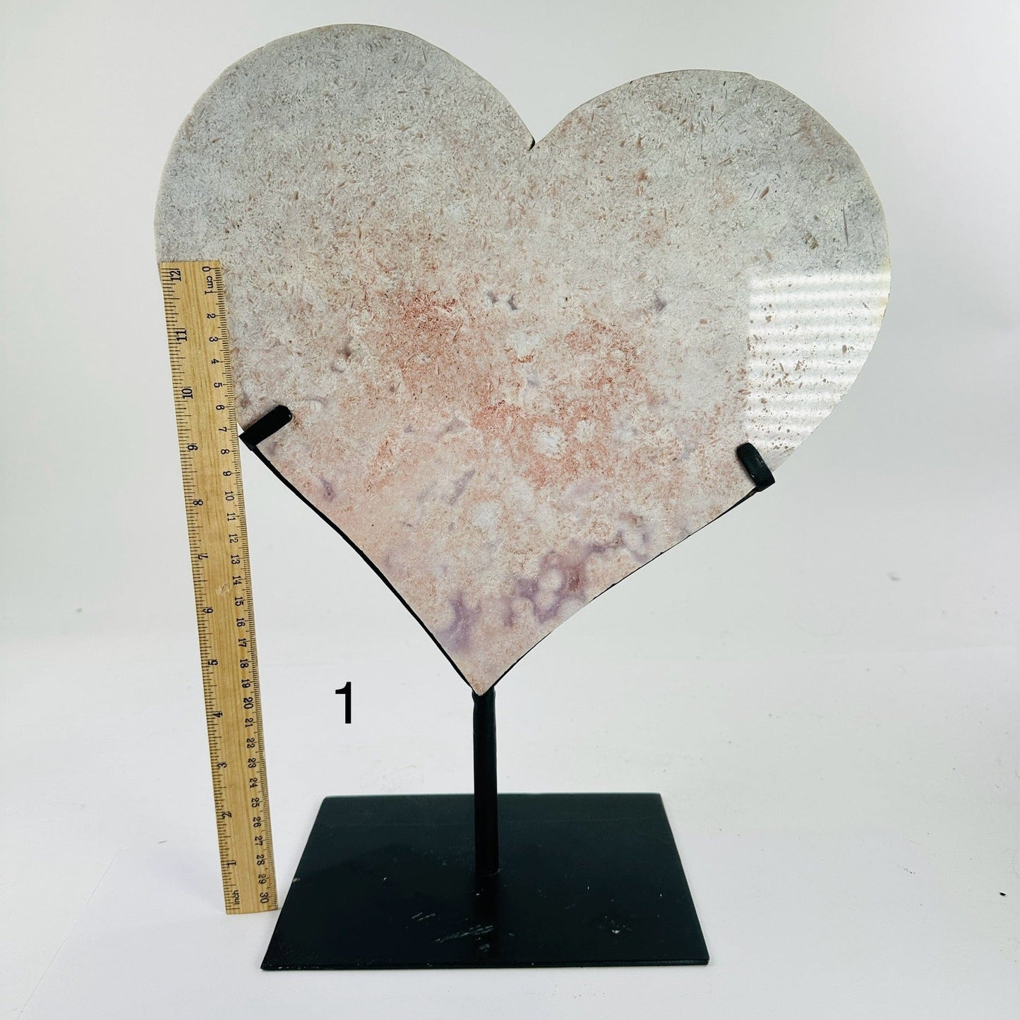 pink amethyst heart on metal stand next to a ruler for size reference