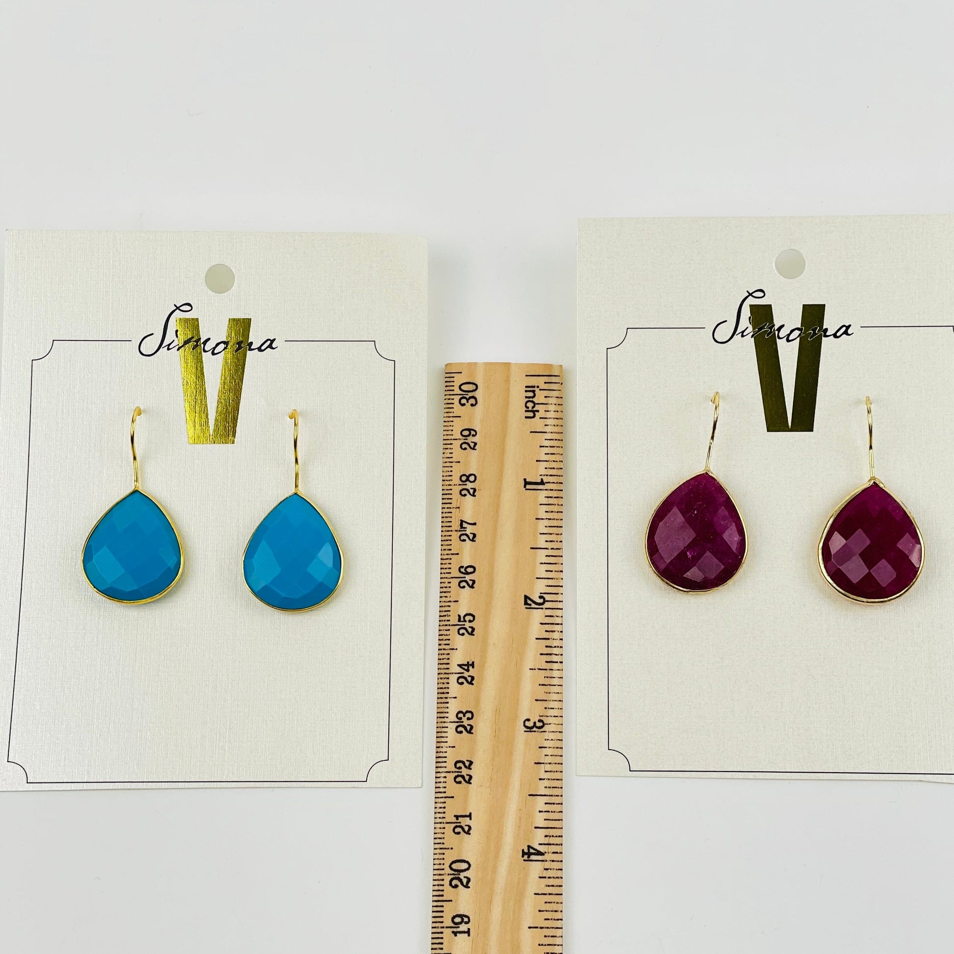 earrings next to a ruler for size reference 