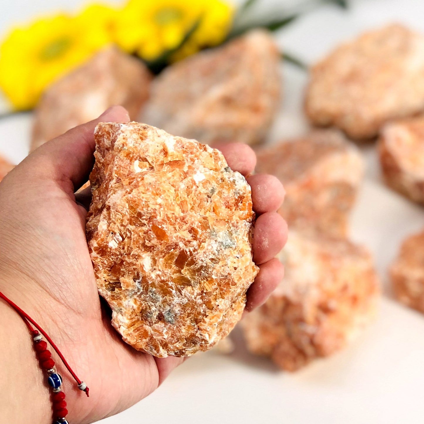Hand holding a large orchid calcite rough stone for size reference 