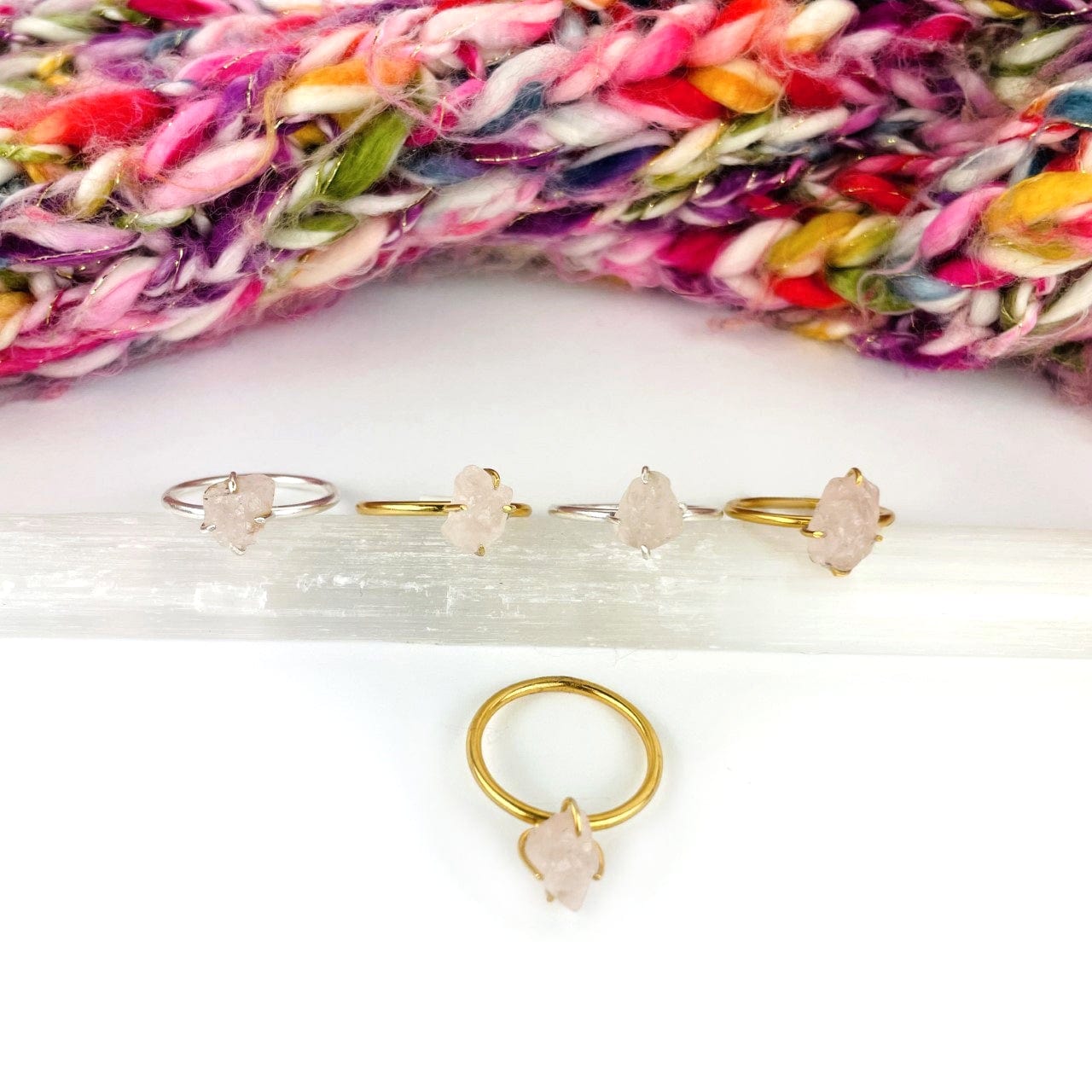 multiple rose quartz rings displayed to show the differences in the gemstone size 