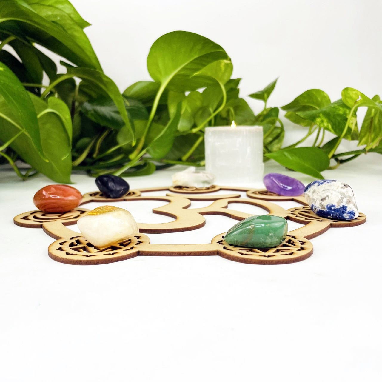 Side view of crystal grid with chakra stones placed on it.  It is about a fourth of an inch thick