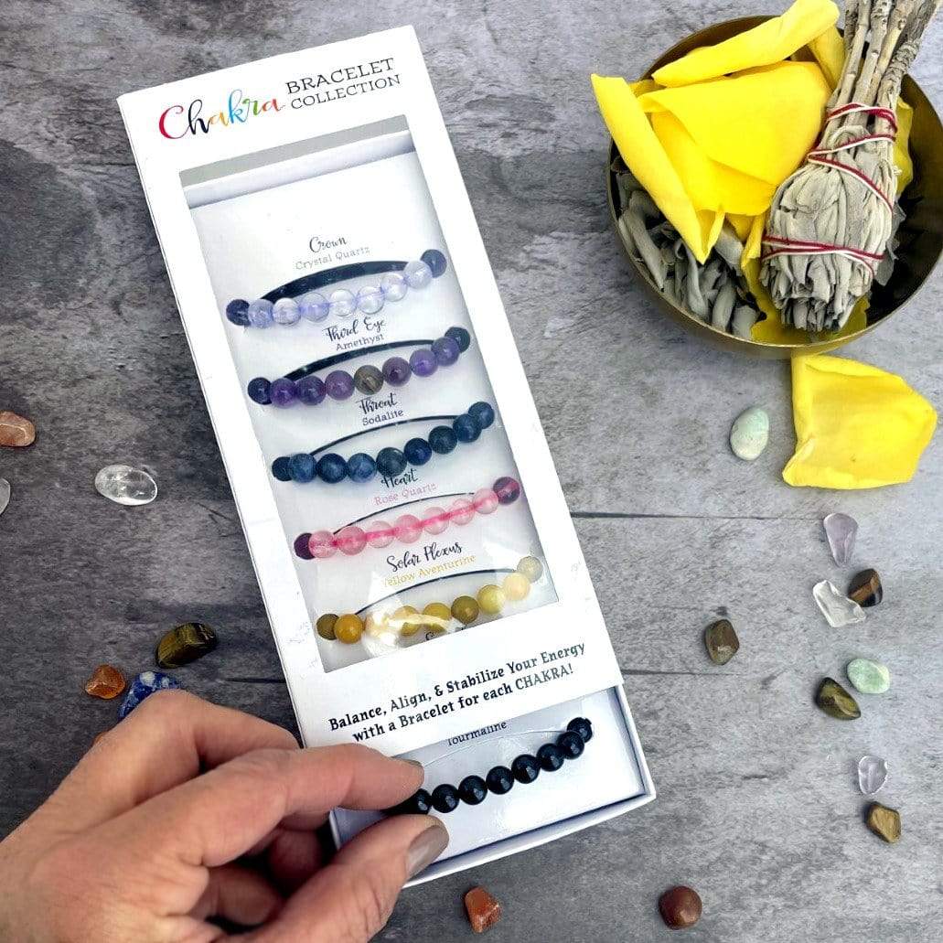 Chakra Bracelet Set - 7 Mala Bead Bracelets in a box with a hand