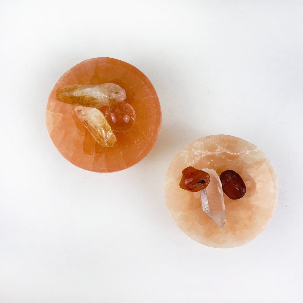 2 Orange Selenite Bowls showing here with small stones inside to give you an idea of bowl depth