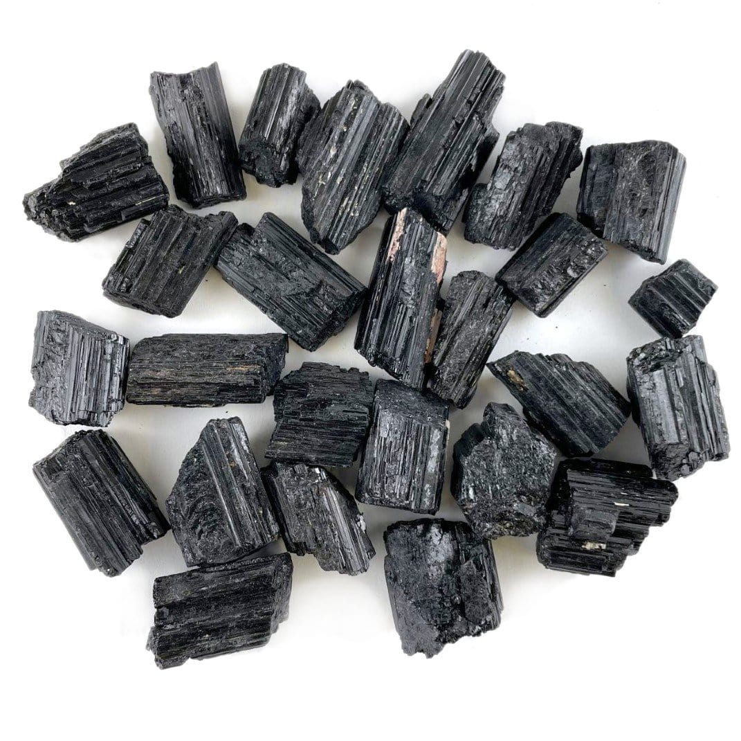 one pound of black tourmaline pendant sized rods on white background 