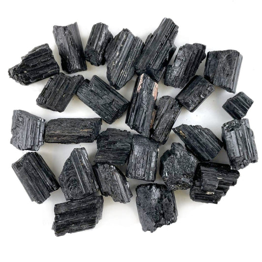 one pound of black tourmaline pendant sized rods on white background 