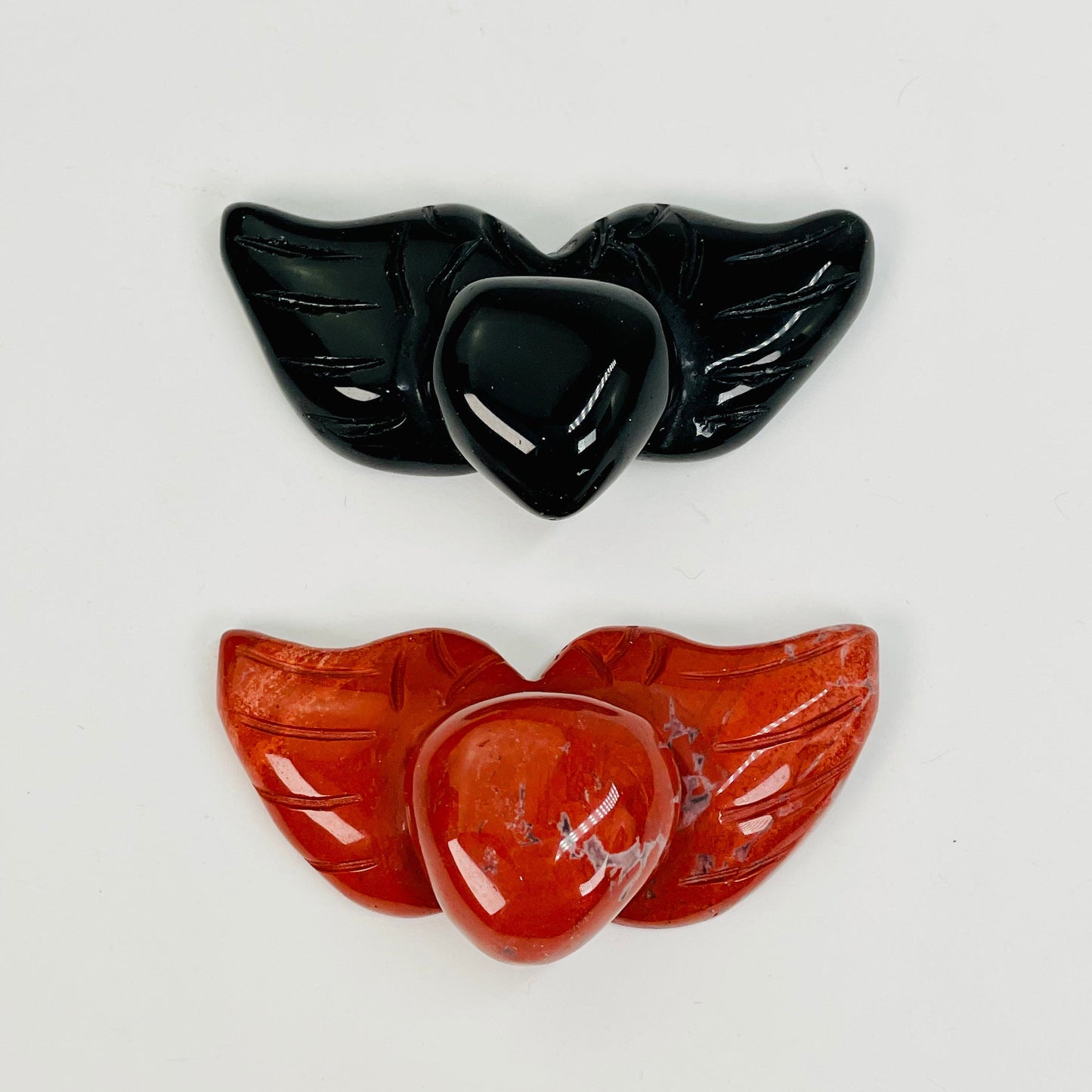 close up of the engraved details on the heart with wings gemstones 