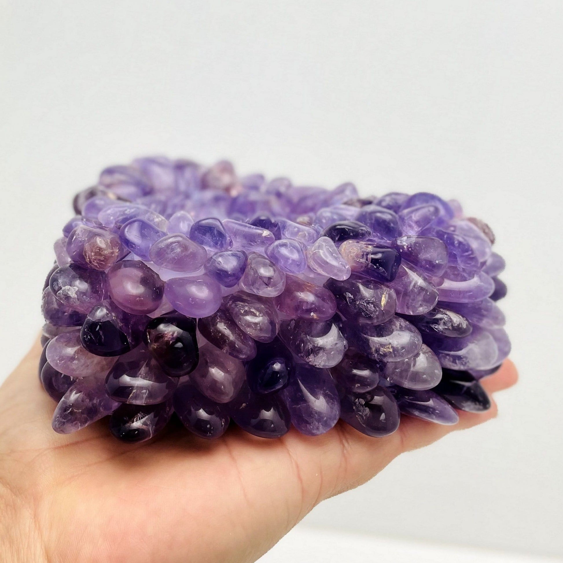 hand holding up amethyst tumbled stone heart candle holder showing the side of it