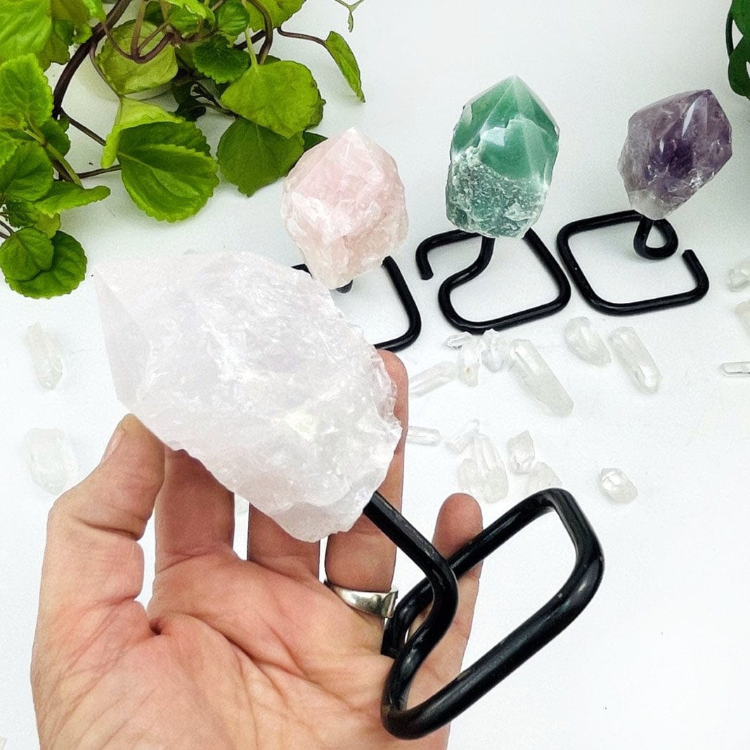 Semi Polished Points on Metal Stands up close of the crystal quartz on in a hand for size reference