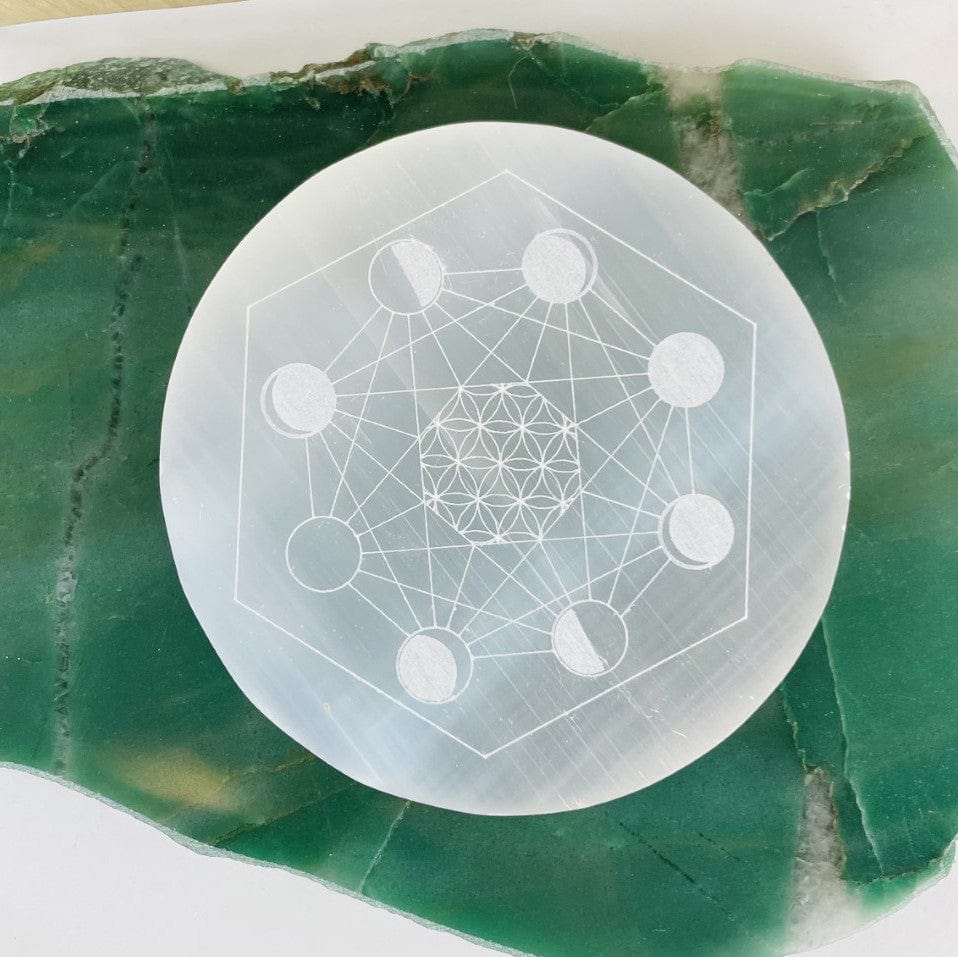close up of selenite moon phase engraved charging plate for engraving details