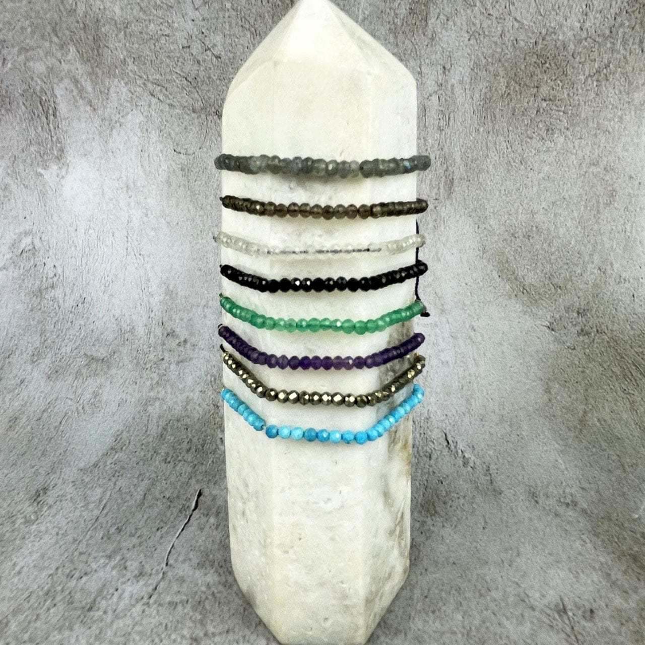 Gemstone Bracelet - Adjustable Cord with Gold Plated over Sterling Silver Beads one of each stone available, pyrite, moonstone, green onyx, labradorite, amethyst, black spinel, smoky quartz, and chinese turquoise all on a crystal dispaly
