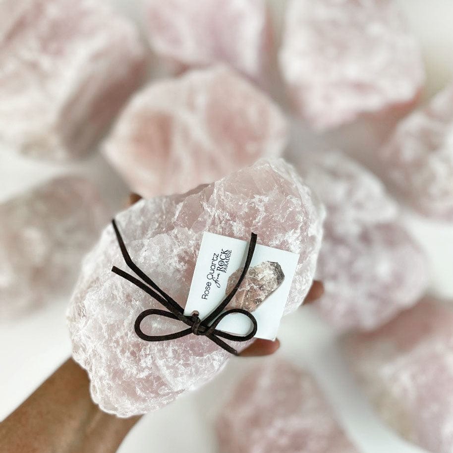 Super size Rose quartz in hand for reference in front of other stones