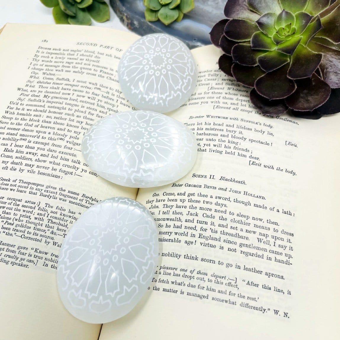selenite mandala engraved palm stones on display