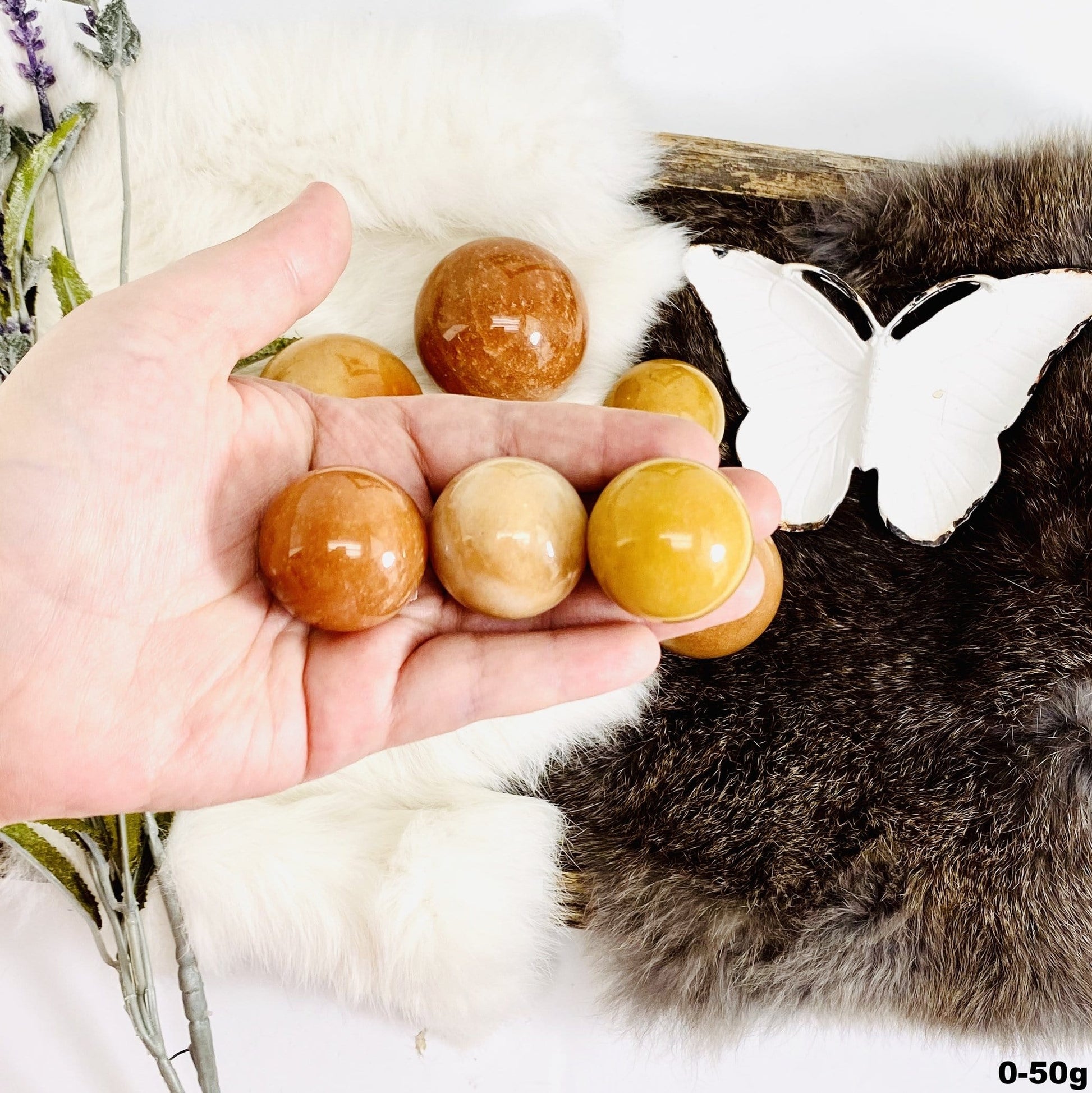 Peach Aventurine Polished Spheres in hand for size comparison size small