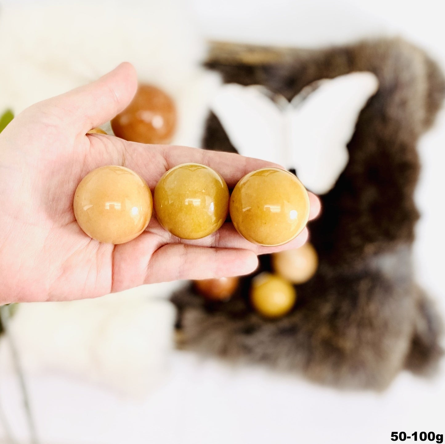 Peach Aventurine Polished Spheres in hand for size comparison size medium