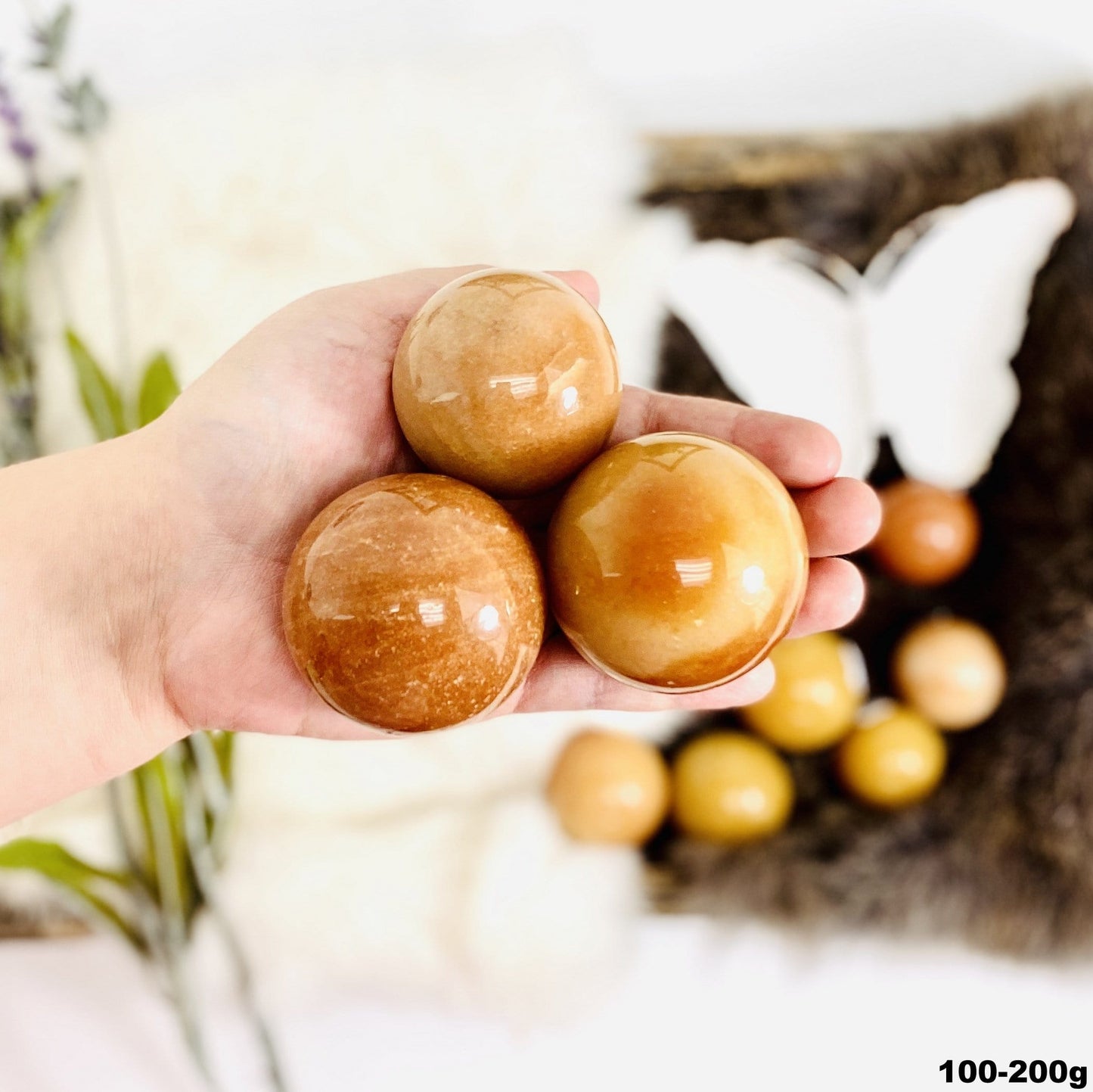 Peach Aventurine Polished Spheres in hand for size comparison size large