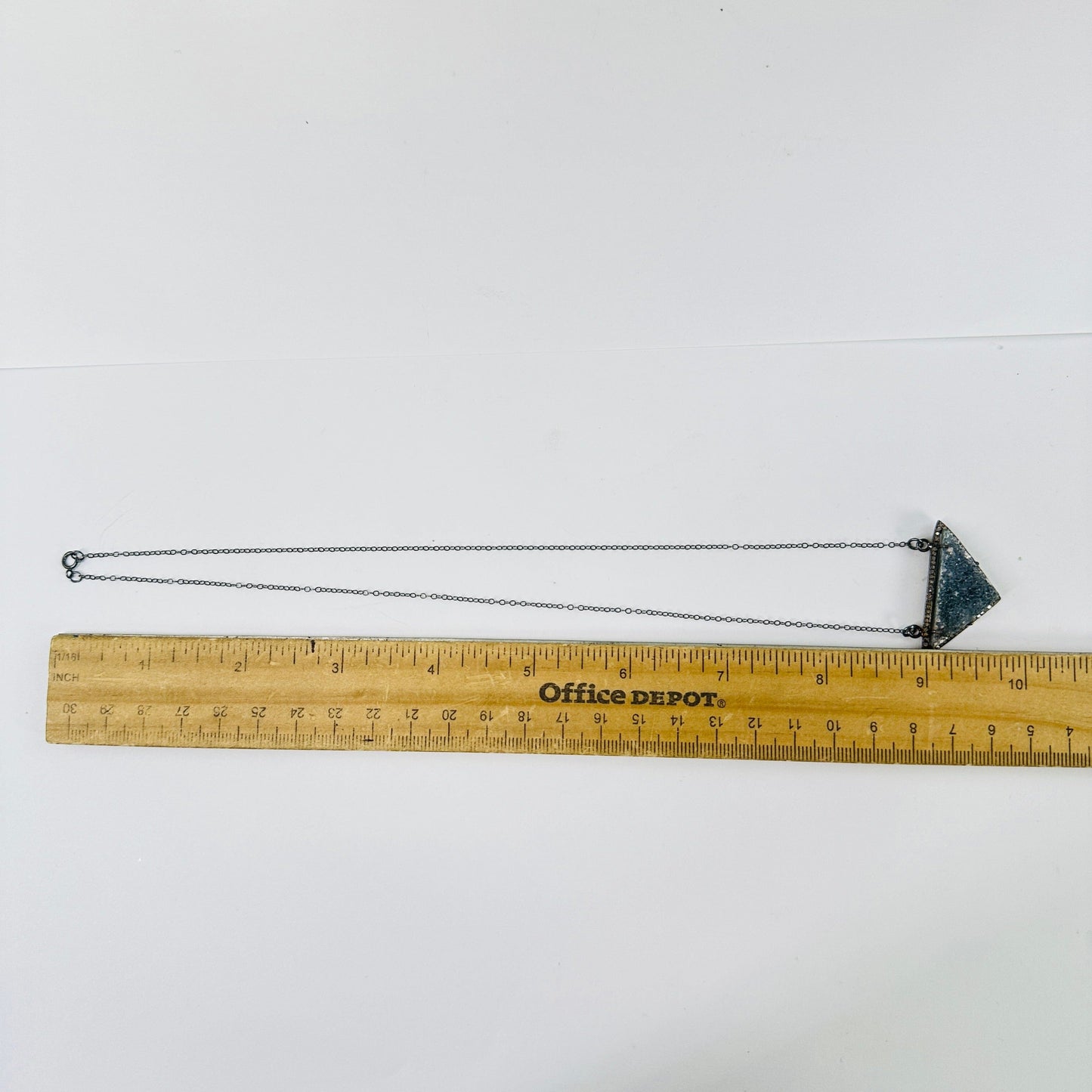 druzy pendant necklace next to a ruler for size reference