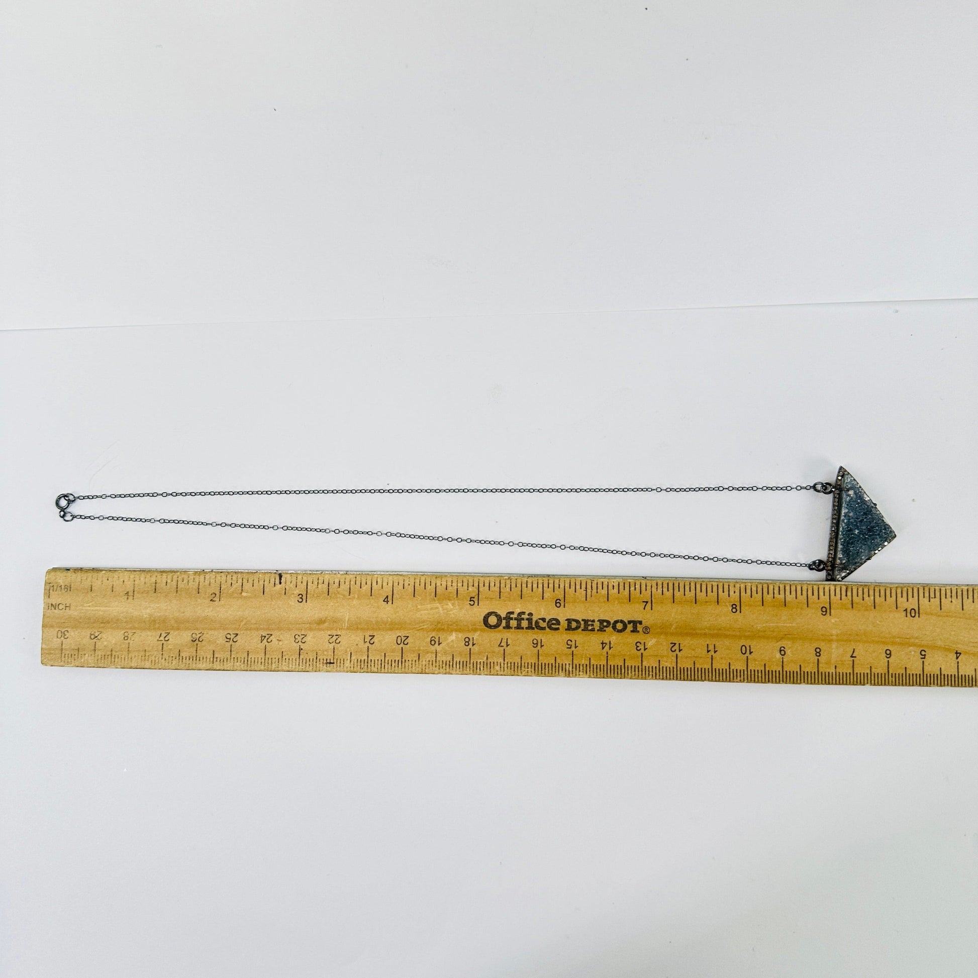 druzy pendant necklace next to a ruler for size reference