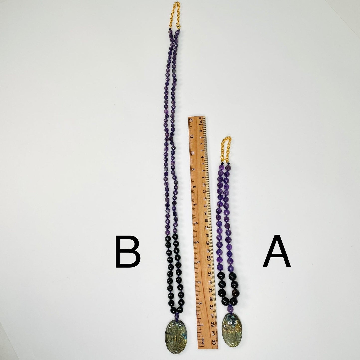 necklaces next to a ruler for size reference 