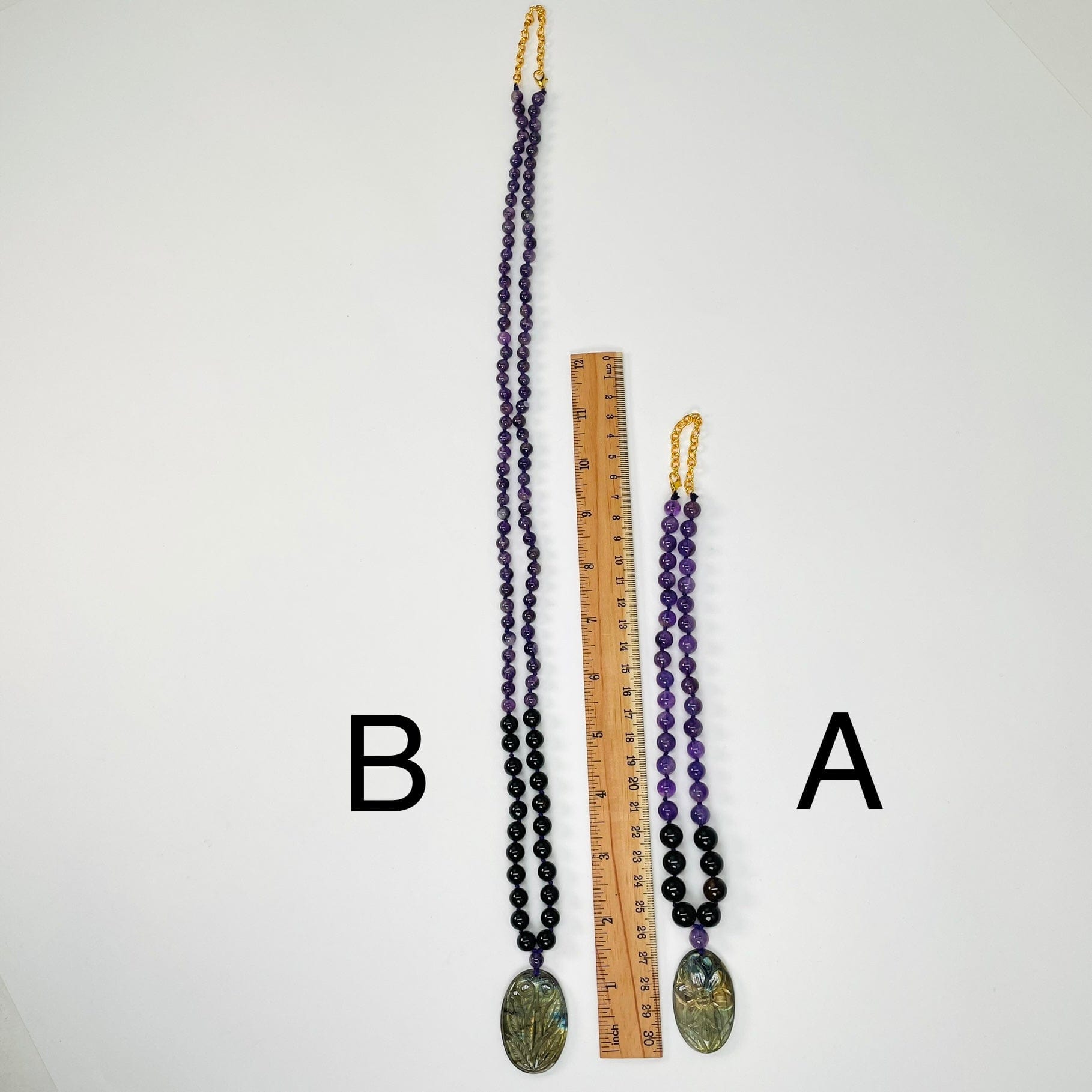 necklaces next to a ruler for size reference 