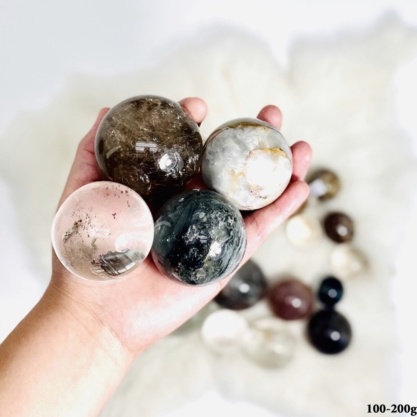 Assorted Quartz Spheres, between 100-200g, displayed in hand