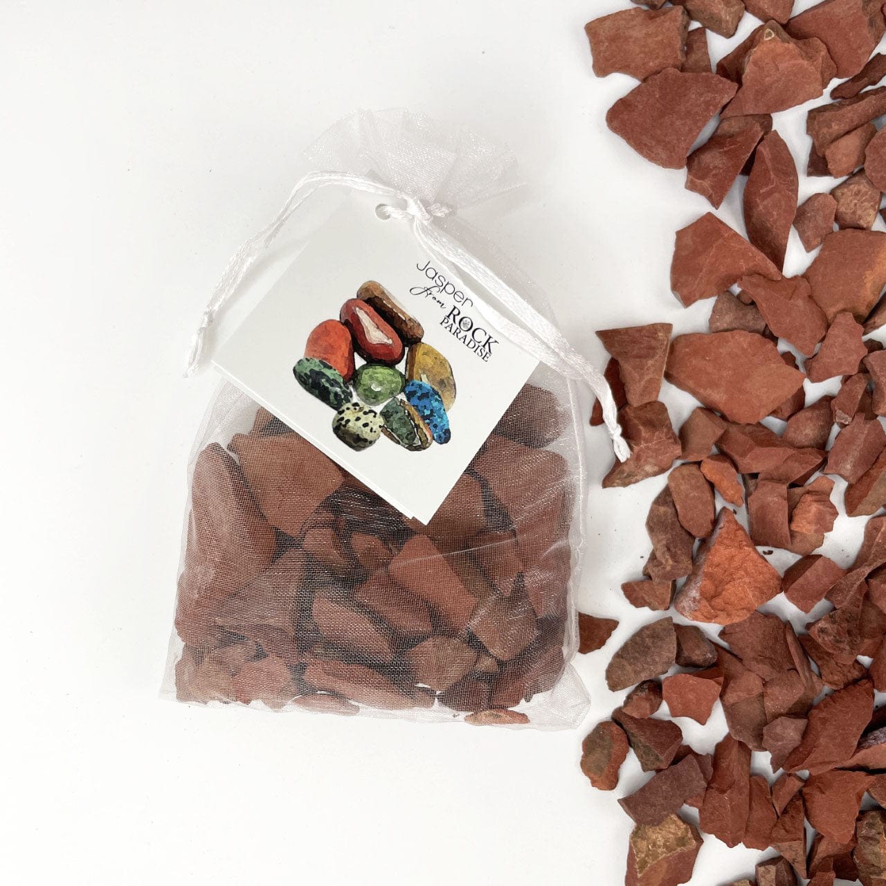 Red Jasper Stones - Tied & Tagged in an Organza Bag next to stones on a table