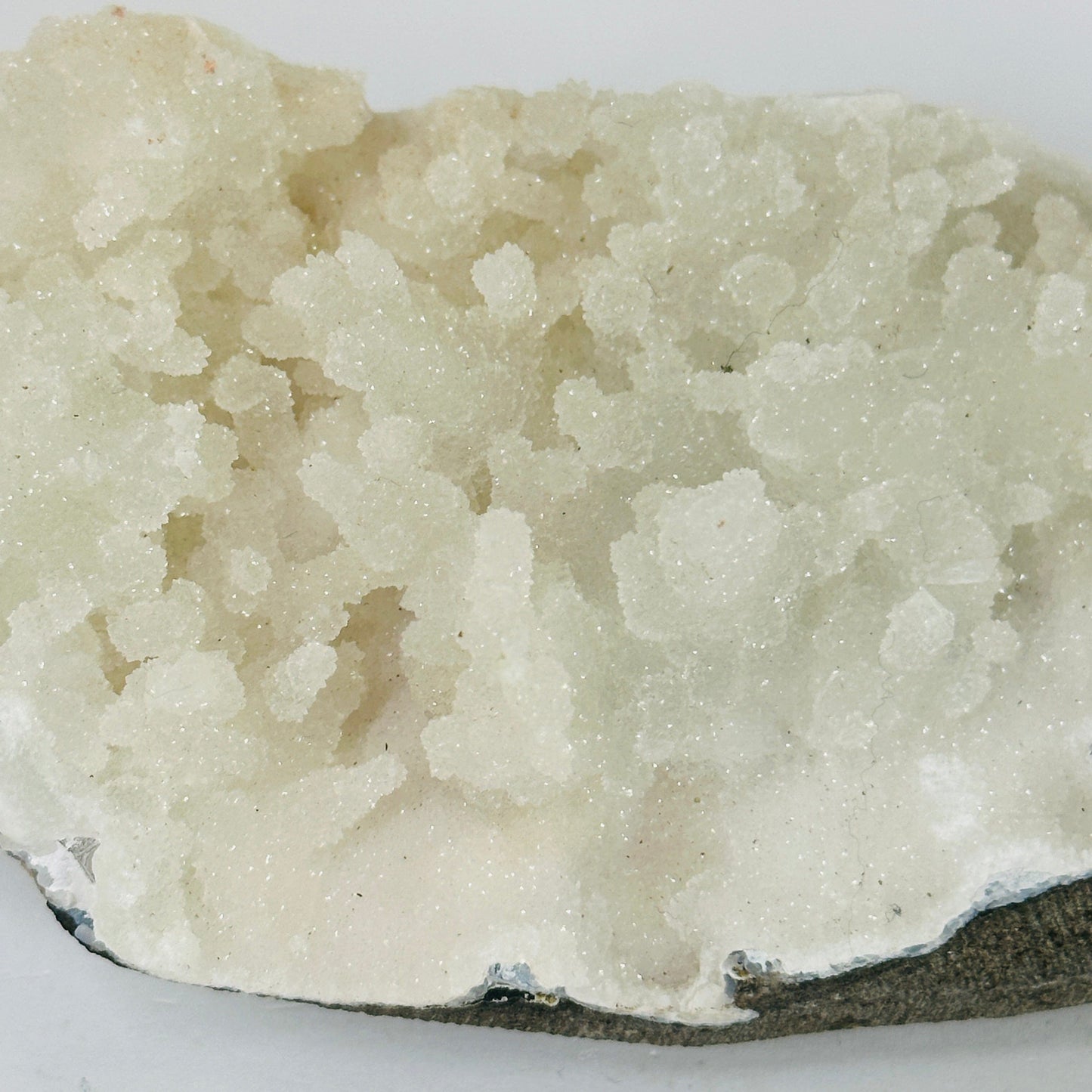 apophyllite on matrix with decorations in the background