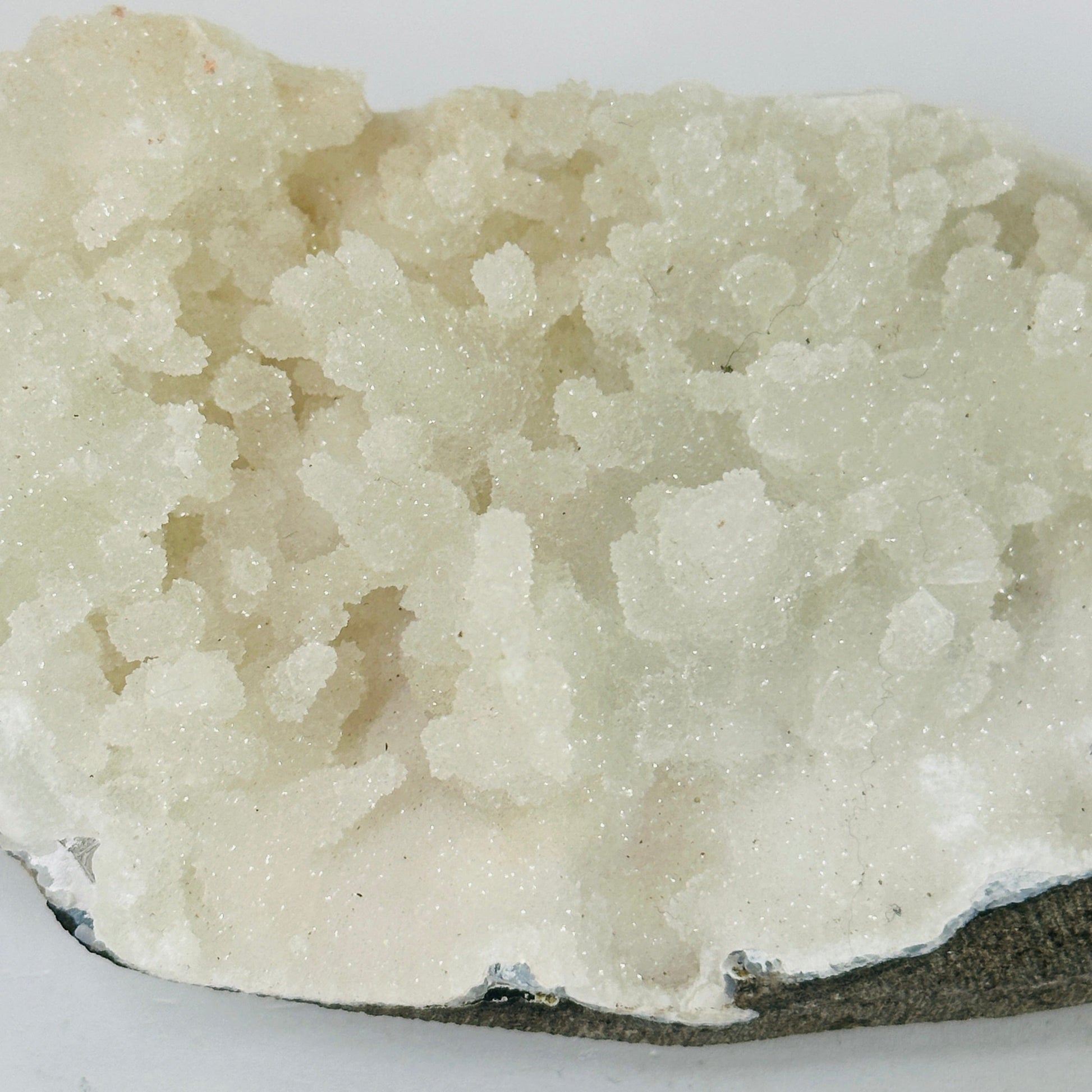 apophyllite on matrix with decorations in the background