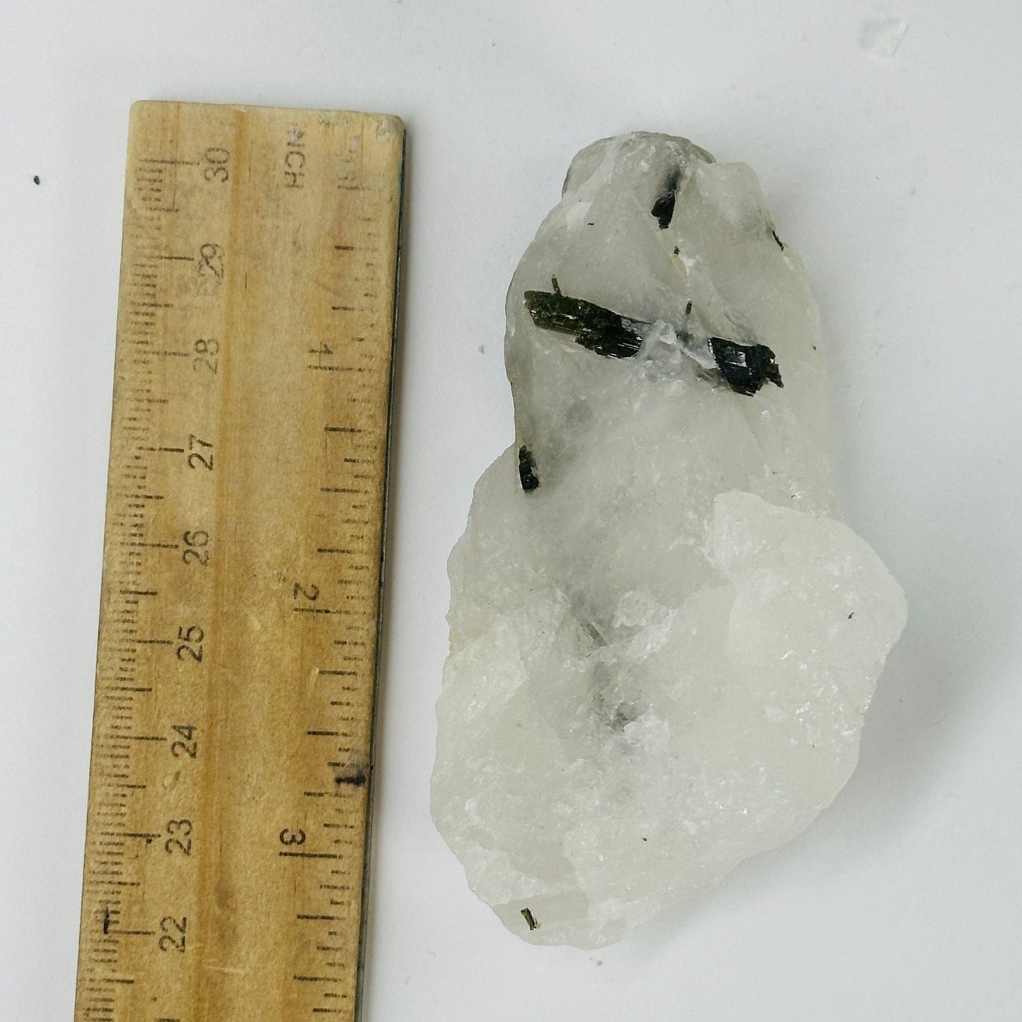 epidote on matrix next to a ruler for size reference