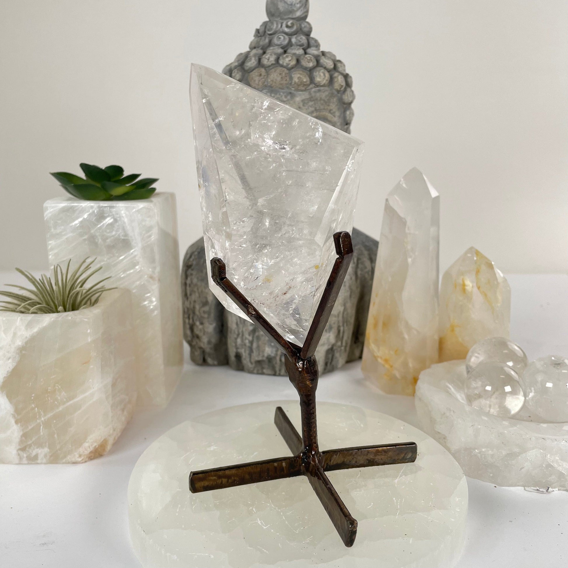 Crystal Quartz Polished Freeform on Metal Stand - One-of-a-Kind front view with props and plants in the background