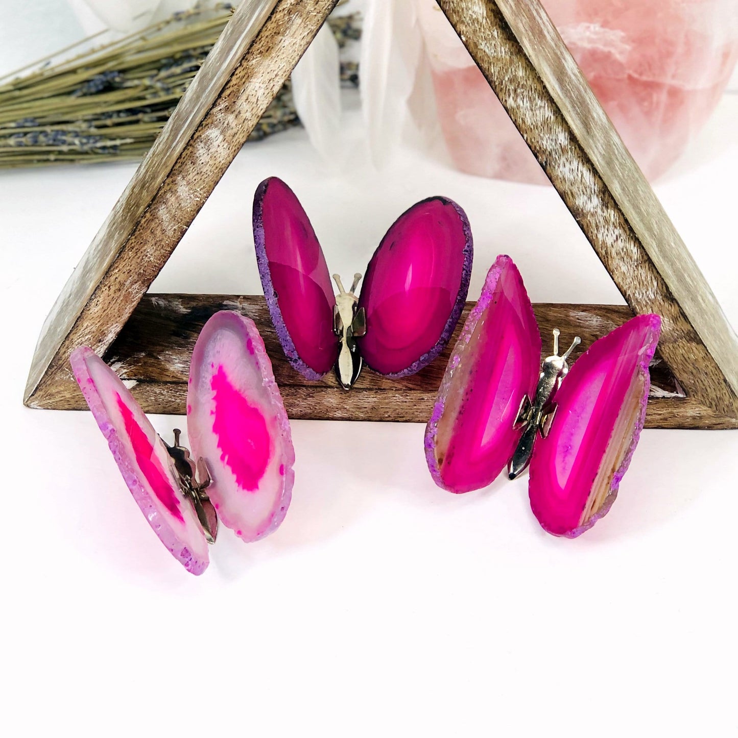 Pink Agate Druzy Butterfly Stands in an alter with crystals and flowers.