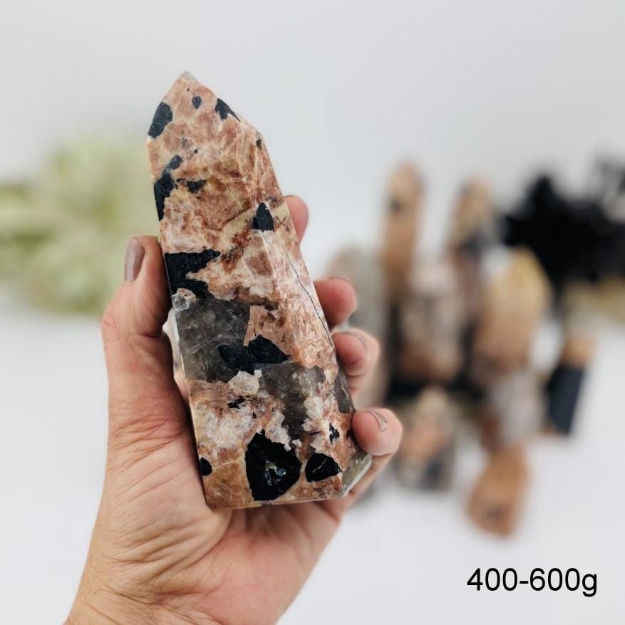 black tourmaline with feldspar polished point in hand for size reference weights between 400-600g