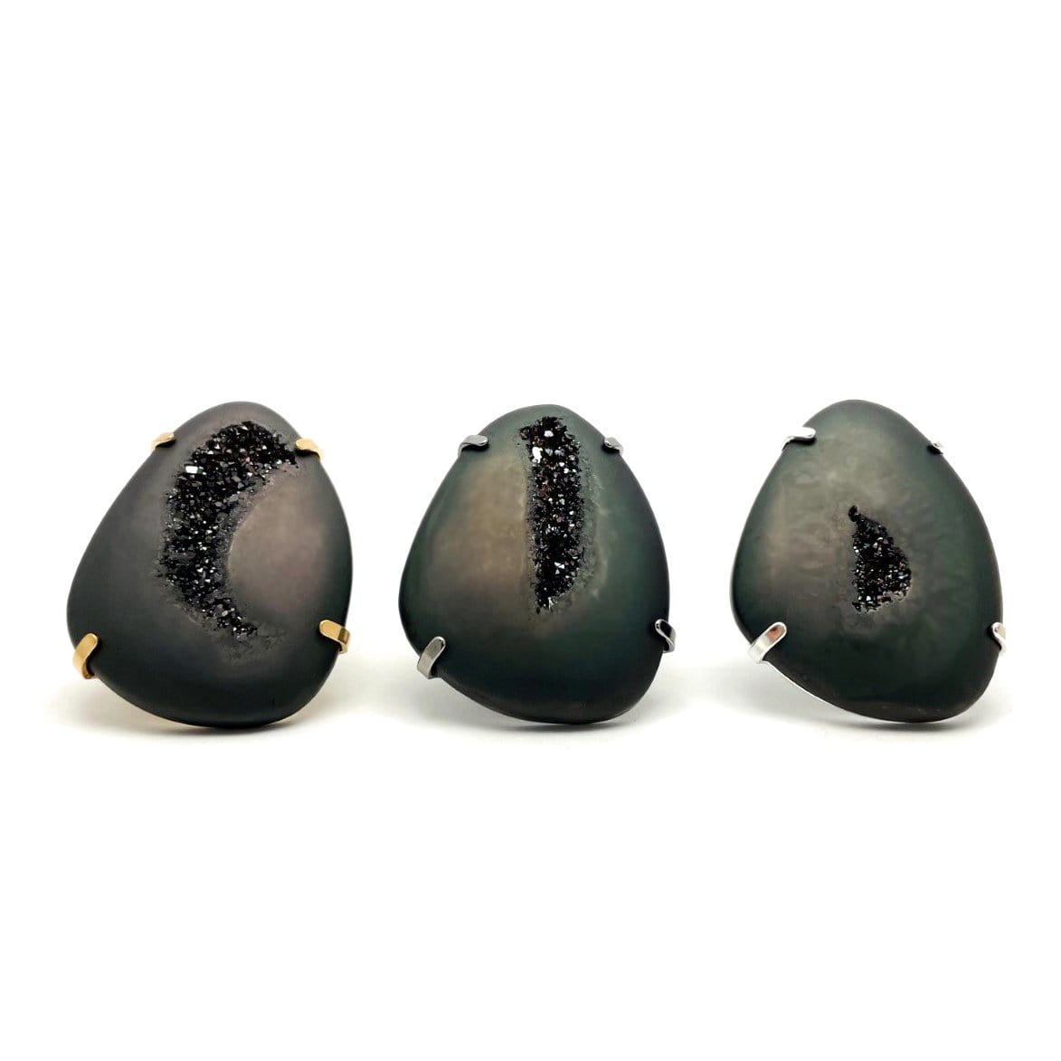 Three black druzy rings on a white background.