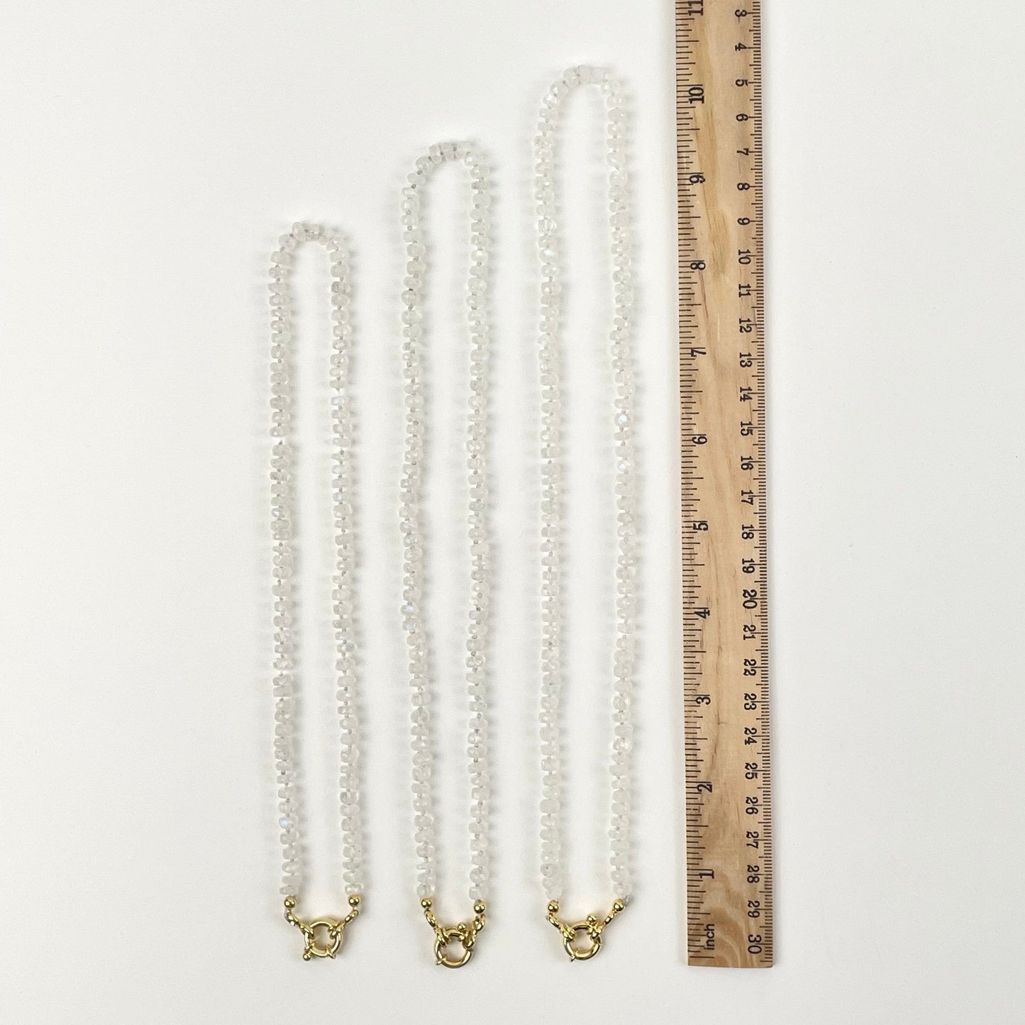 necklaces next to a ruler for size reference 