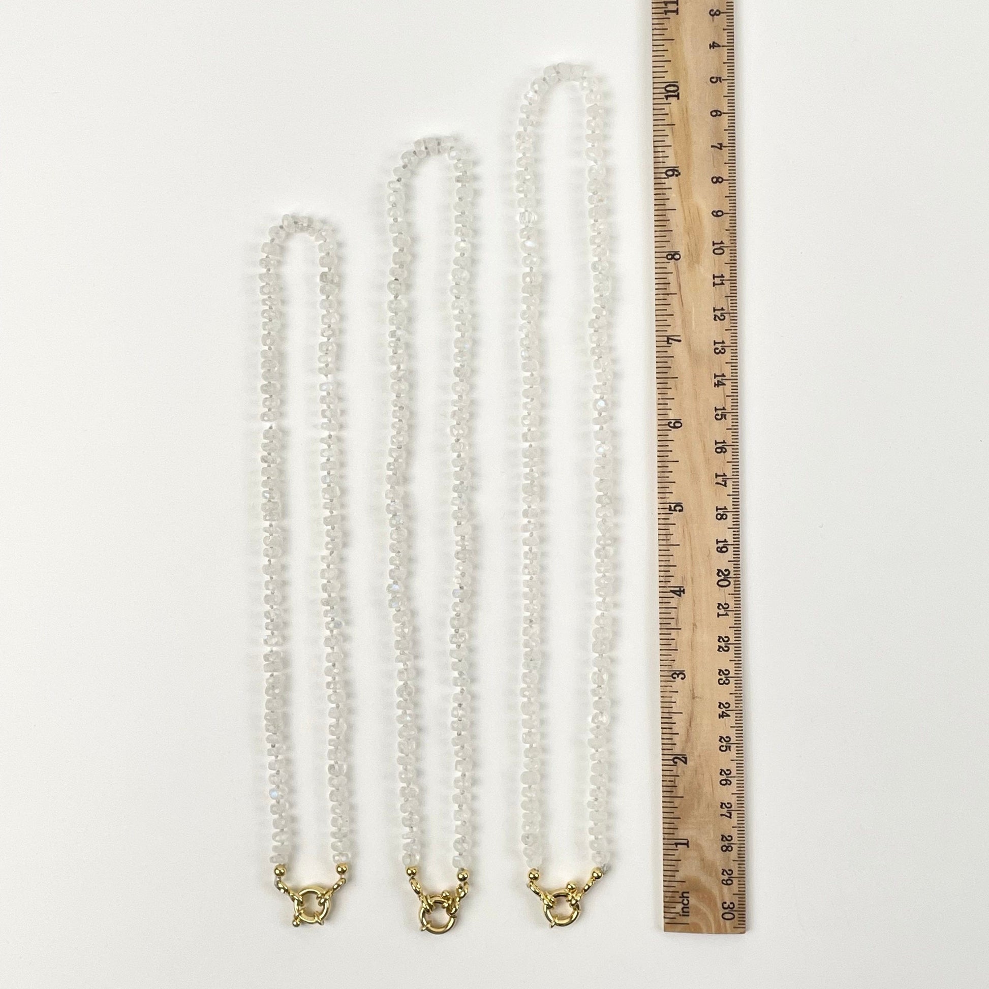 necklaces next to a ruler for size reference 