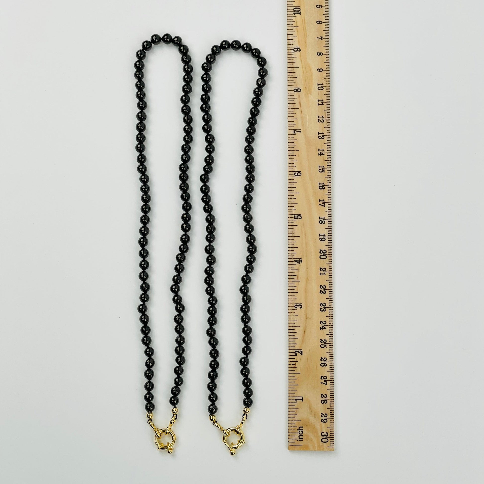 2 Shungite Candy Necklaces next to a ruler for size reference