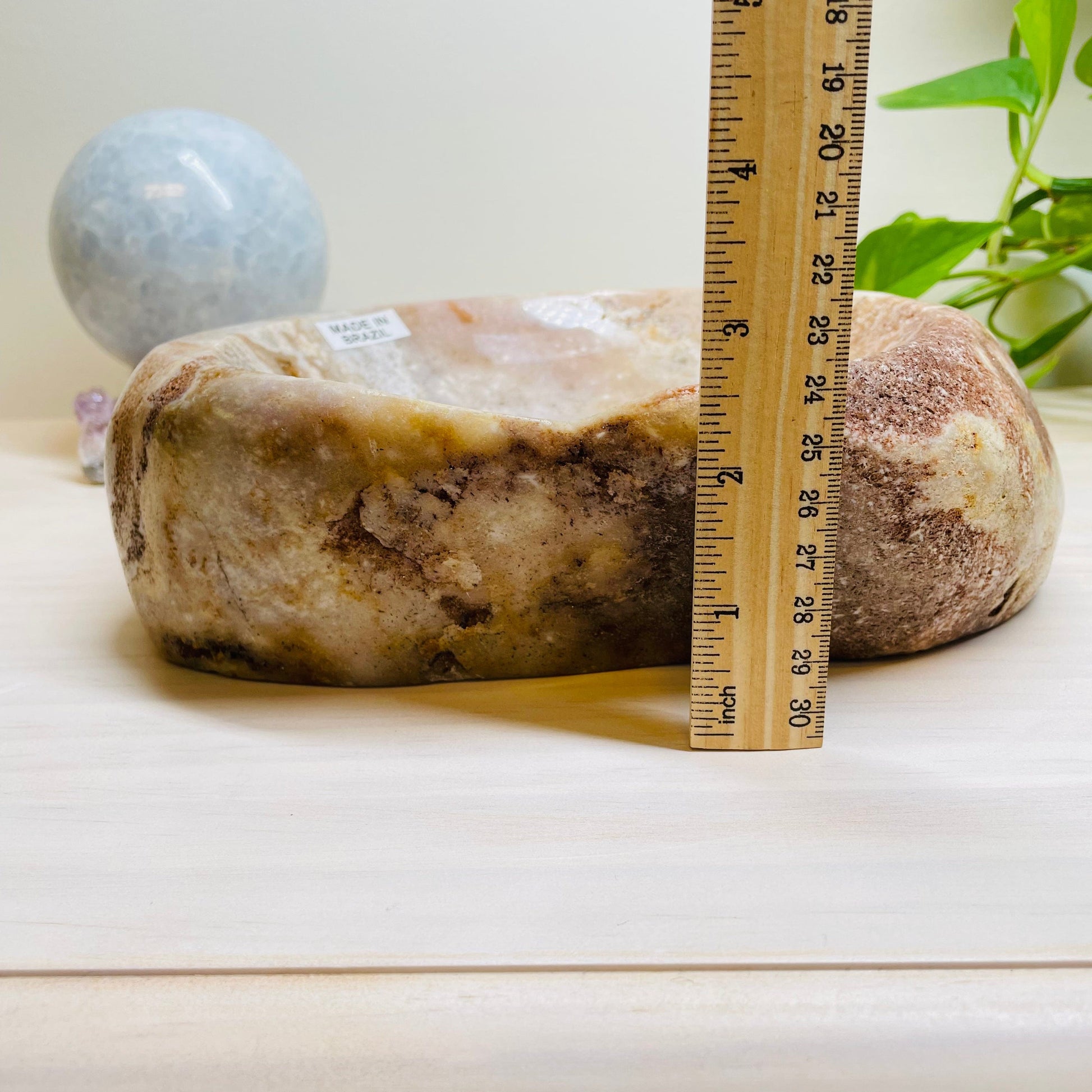 pink amethyst bowl next to a ruler for size reference 