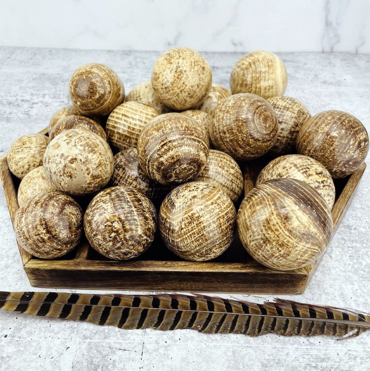 Aragonite Polished Spheres stacked on top of each other shoing different colors of brown and cream tones