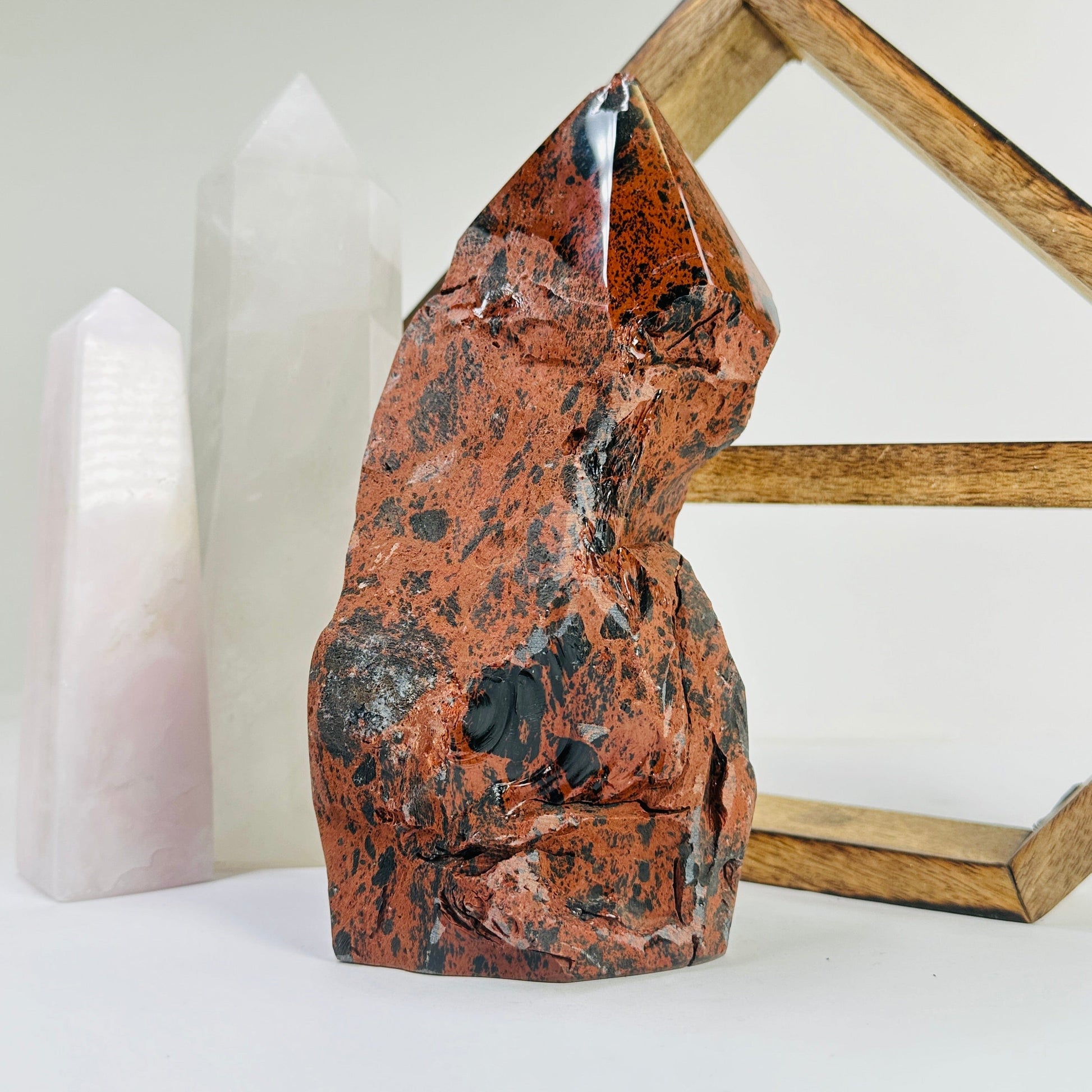 mahogany obsidian point with decorations in the background