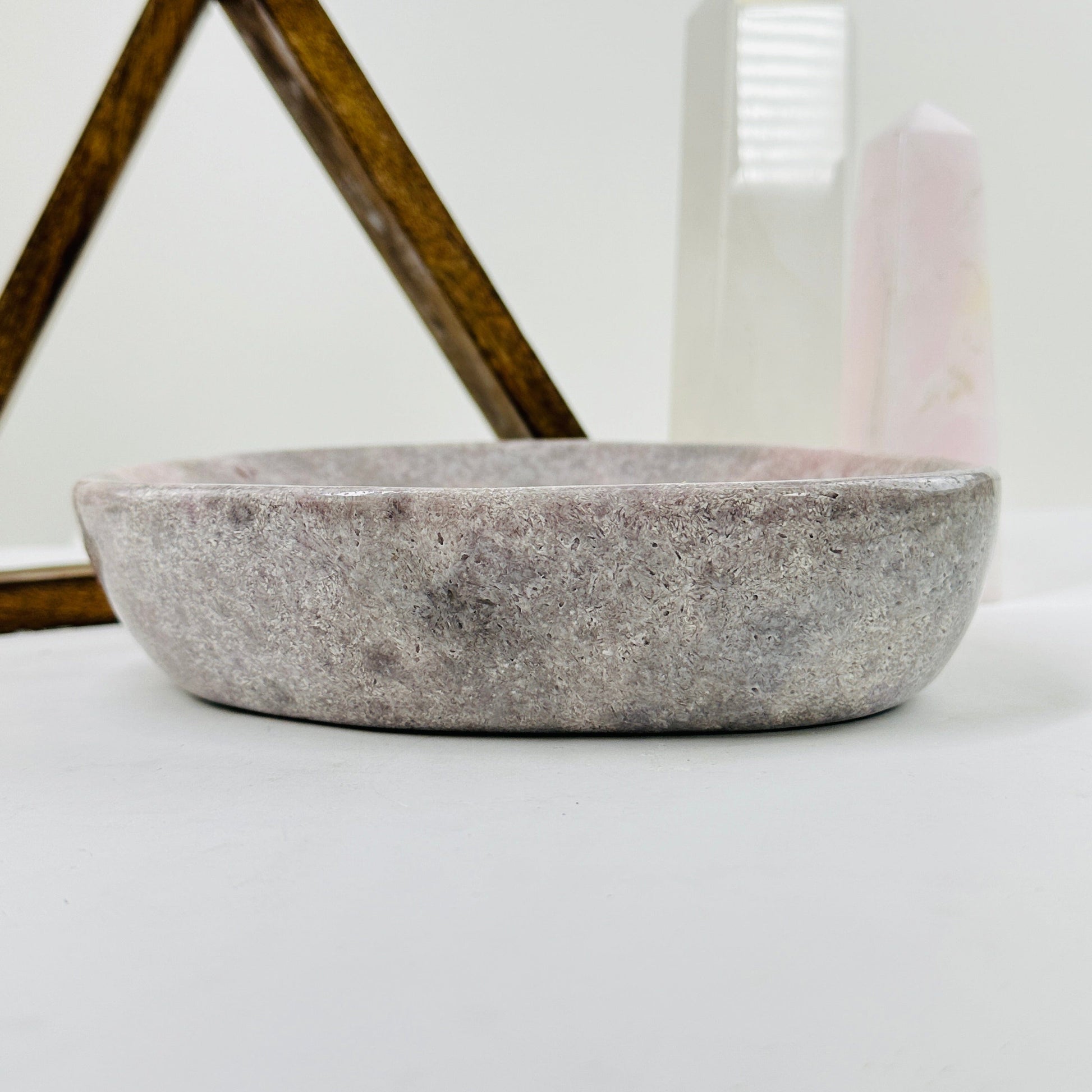 side view of pink amethyst plate with decorations in the background