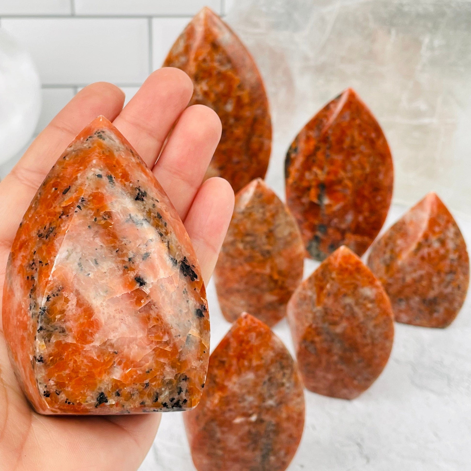 Orange Calcite Flame Point in hand for size reference 